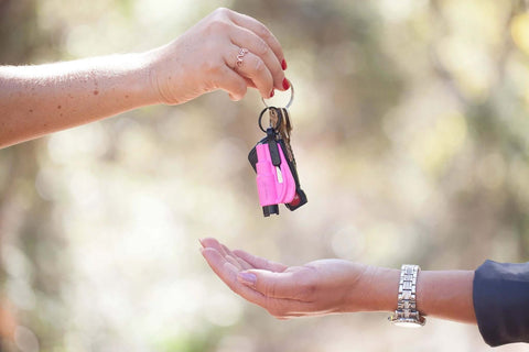 Pink resqme emergency keychain tool on a keyring with car keys, 2-in-1 seatbelt cutter and window breaker