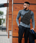 Man wearing Rugged Tactical Molle Sling Bag with Single Strap For Men EDC Everyday Carry Pack for outdoor activities.