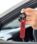 Person holding Personalized Embroidered Keychain With Double Sided Name Text. Red keychain close-up view with car key.