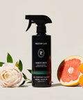 Luxurious All Purpose Cleaner With Doheny Drive Scent bottle surrounded by grapefruit and flowers, 500 ml black spray bottle