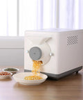 Automatic Coffee Bean Roaster With Nonstick Electric Pan For Peanuts Cashews And Chestnuts Featuring Adjustable Heat And Timer Knobs For Smooth No Sweat Home Roasting Top Shelf Results, with roasted seeds flowing into a dish.