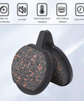 Close-up view of two round bicycle disc brake pads with copper-speckled friction surface in black housings