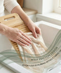 No Sweat Bamboo Washboard For Hand Washing Clothes With Non Slip Base and Deep Grooves being used to scrub fabric in a sink.