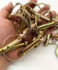 Hand holding O-Ring Lynch Pin Set 50-Piece Steel Quick-Release Pins For Tractors And Trailer Hitches showcasing durable design