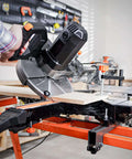 DOVAMAN 10-inch sliding miter saw, side view, cutting wood on an orange stand.