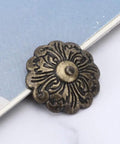 30 Piece Retro Zinc Alloy Upholstery Tacks And Furniture Nails 22mm Round Heads With 10mm Shank For Sofa Chair Bed DIY Makeovers To Snag Quick Fixes And Level Up Your Home Digs Today decorative bronze tack with floral design on fabric surface.