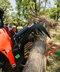 72 Inch Manure Tine Grapple Bucket Attachment With SSQA Hay Spear Frame lifts log, showcasing double grapple rake arms in action
