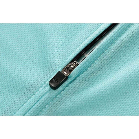 Close-up of a turquoise fabric zipper on a garment, with textured material and silver zipper teeth visible.
