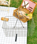 Heavy Duty Iron Shopping Basket With Cushioned Ergonomic Handle Straight Up Durable Grocery Tote For Home Market And Kitchen Runs No Sweat Heavy Load Errand Caddy hanging above a picnic setup.