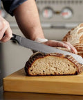 Pro CBN Grinding Wheel For Sharpening Bread Knife Serrations With Steel Adapter Arbor Reliable Rotary Tool Fit For Fast Kitchen Chopping And Sharp As A Tack Edges All Day Long, slicing sourdough bread with a serrated knife.