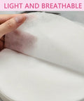 Hand holding lightweight sheet from 200 Sheets Disposable Nail Dust Filter Papers for Most Nail Dust Collectors and Vacuums.