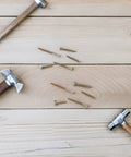 Hammers and nails on wooden surface