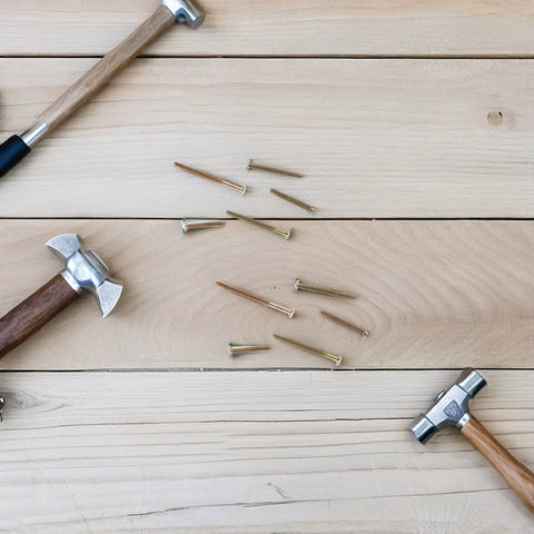 Hammers and nails on wooden surface