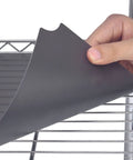 Hand holding Heavy Duty Quilted Plastic Wire Shelf Liner 18 x 48 Inches Non Slip Protective Mat being placed on wire rack.