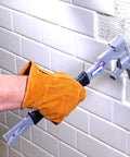 15 Inch Multi Function Demolition Tool Nail Puller With Cross Hatch Hammer in use breaking tile by a gloved hand