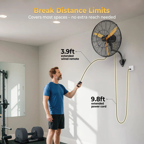 Man using remote control for 24 Inch Oscillating Misting Wall Mount Fan With Extended Wired Remote And Nine Point Eight Foot Power Cord