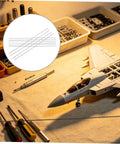 10 Pack Carbon Fiber Round Rods For RC Models near RC plane model on workbench with tools and parts