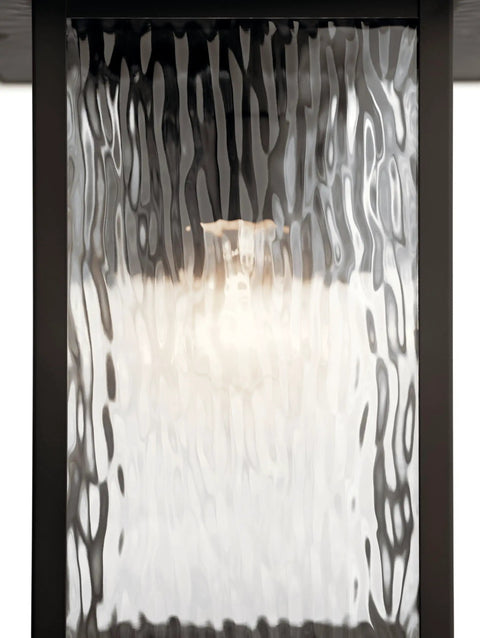 Close-up of Capanna Outdoor Wall Light In Olde Bronze With Clear Water Glass, showcasing the textured clear water glass.