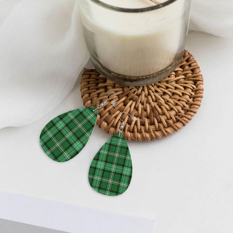 Totally Fire Green Grid Teardrop Faux Leather Dangle Earrings With Silver Plated Hooks resting on a woven coaster.