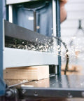 Smooth As Glass 15 Amp Benchtop Thickness Planer in action, smoothing rough lumber with dual hardened steel cutters.