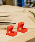 4 Piece Ratchet Woodworking Strap Clamp Blocks Set on a wooden workbench, orange blocks used for quick fix band clamps.
