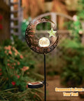 Lit Moonlit Solar Lantern For Outdoor Decor Ideal For Patio Path Garden Or Lawn Crackle Glass Globe Stake Light Waterproof Bronze Finish Warm LED Glow Easy Sun Powered Setup Upgraded Battery And Large Solar Panel in a garden setting.