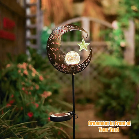 Lit Moonlit Solar Lantern For Outdoor Decor Ideal For Patio Path Garden Or Lawn Crackle Glass Globe Stake Light Waterproof Bronze Finish Warm LED Glow Easy Sun Powered Setup Upgraded Battery And Large Solar Panel in a garden setting.