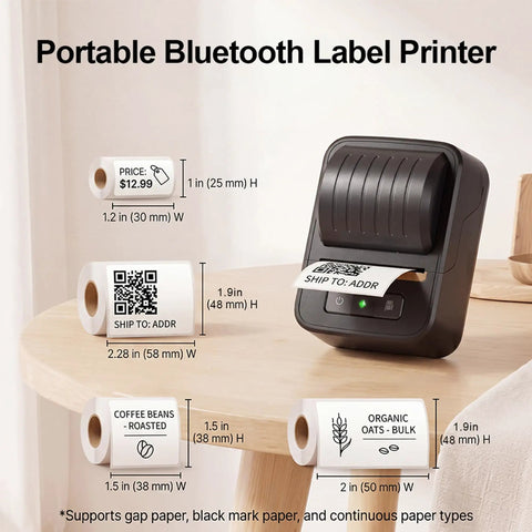 Awesome Bluetooth Label Maker Machine Printing On White Color Clear Thermal Labels With Tape For Home Business Organization Crisp Graphics No Ink Needed 2 Inch Wide Portable Handy Tech Gadget on a wooden table with various labels.