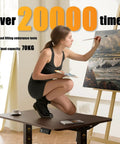 Woman painting on Electric Standing Desk Lifts Adjustable Height From 18.9 To 29.5 Inches With Lockable Wheels And Smooth Motor For Home Office Ergonomic Computer Desk Setup Easy One Touch Control.