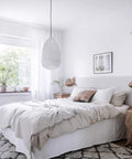 Peel And Stick White Wallpaper Self Adhesive in a cozy bedroom with textured walls, bed, and plants by window.