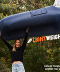 Person holding Inflatable Couch Air Lounger Chair No Pump Needed For Camping And Beach Trips, Lightweight, in a forest setting.