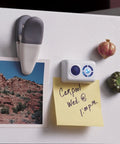 Fridge with photo, note, and magnets, including a clip and decorative magnets, displaying a carpool reminder at 1 p.m.