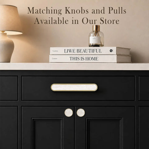 4 Pack Gold Cabinet Pulls With Pearl Inlay And Brushed Brass Base on black dresser with decorative items