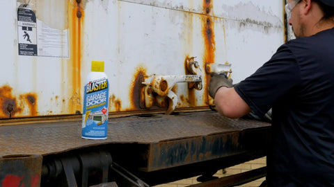 Worker applying Silicone Garage Door Lubricant Spray For Smoother Quieter Operation On Tracks Rollers And Hinges Will Not Attract Dust Or Dirt Tack Free Formula Reduces Friction And Noise So Your Door Roars Less And Moves Smoothly 9.3 Oz Case Of 12 to rusty metal surface