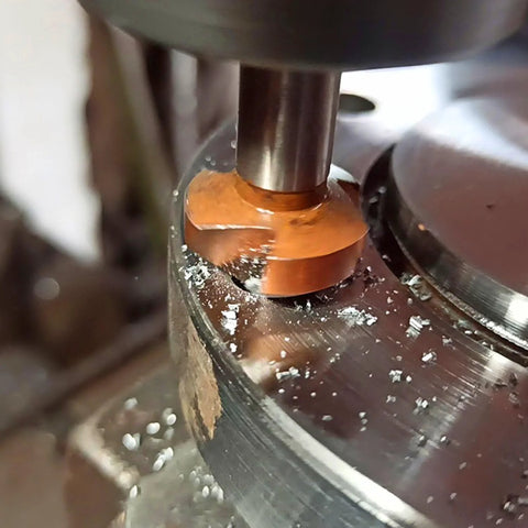 TJR countersink bit, 90°, orange-coated HSS, mounted in a drill press cutting metal