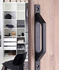 Four Piece Carbon Steel Sliding Barn Door Handle Set In Matte Black Finish installed on wood door, modern interior background