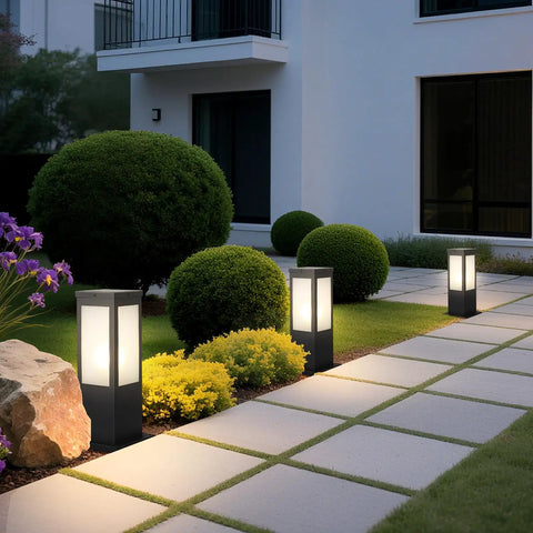 Rock Solid 15.75 Inch Outdoor Bollard Path Lights With Knockout Aluminum Frame And Frosted Glass Shade illuminating a garden pathway.