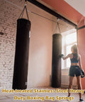 Woman training with hanging boxing bag suspended by Six Pack Heavy Duty Swing Springs, 3000 Lbs Capacity for gym use.