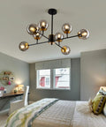 Bedroom with Eight Light Mid Century Glass Globe Chandelier, farmhouse gold finish, modern design, lit showpiece lighting.