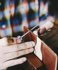 Person using Badass Professional Grade Three Pack Leather Awl Tools with grippy handles for precise leather stitching.