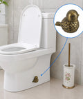 Super Dope Bronze Ceramic Toilet Bolt Covers Featuring Charming Bird Sculpture on white toilet, concealing floor anchors.
