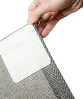 Hand applying Non Slip Rug Pad Grippers For Hardwood And Tile, Double Sided Rug Tape Keeps Area Rugs Flat And Safe, 3.9 inch square.
