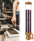 Wall Mounted Coffee Bean Dispenser With Large Capacity Clear Acrylic Storage Jar holding whole beans in a cafe setting.