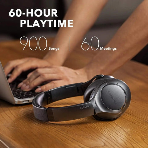 All Day Wireless Over Ear Headphones With Active Noise Canceling, 60 Hour Battery Life, placed on a table next to a laptop