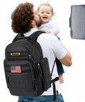 Military Style Dad Diaper Backpack With Changing Pad For Travel And Camping Trips Large black baby bag and father holding child.