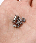 Top Shelf 13 Piece Titanium Screw Kit For Benchmade Bugout 535 Repair with T10 Torx and T6 fasteners in a hand.