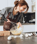 Woman baking with Copper Wrist Compression Sleeves For Carpal Tunnel And Arthritis, Breathable And Comfy Wrist Support Unisex Size M.
