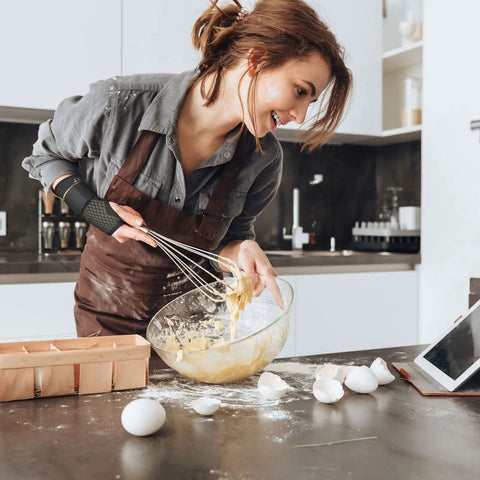 Woman baking with Copper Wrist Compression Sleeves For Carpal Tunnel And Arthritis, Breathable And Comfy Wrist Support Unisex Size M.