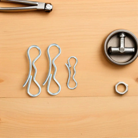 Bow Tie Lock Cotter Pins And Deck Clip Fasteners Assortment Kit for heavy duty trailer hitches on wooden background.
