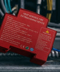 Compact Automatic Car Fire Extinguisher With Quick Aerosol Blast For Instant Emergency Road Safety And Slick Center Console Stash on a metal surface.